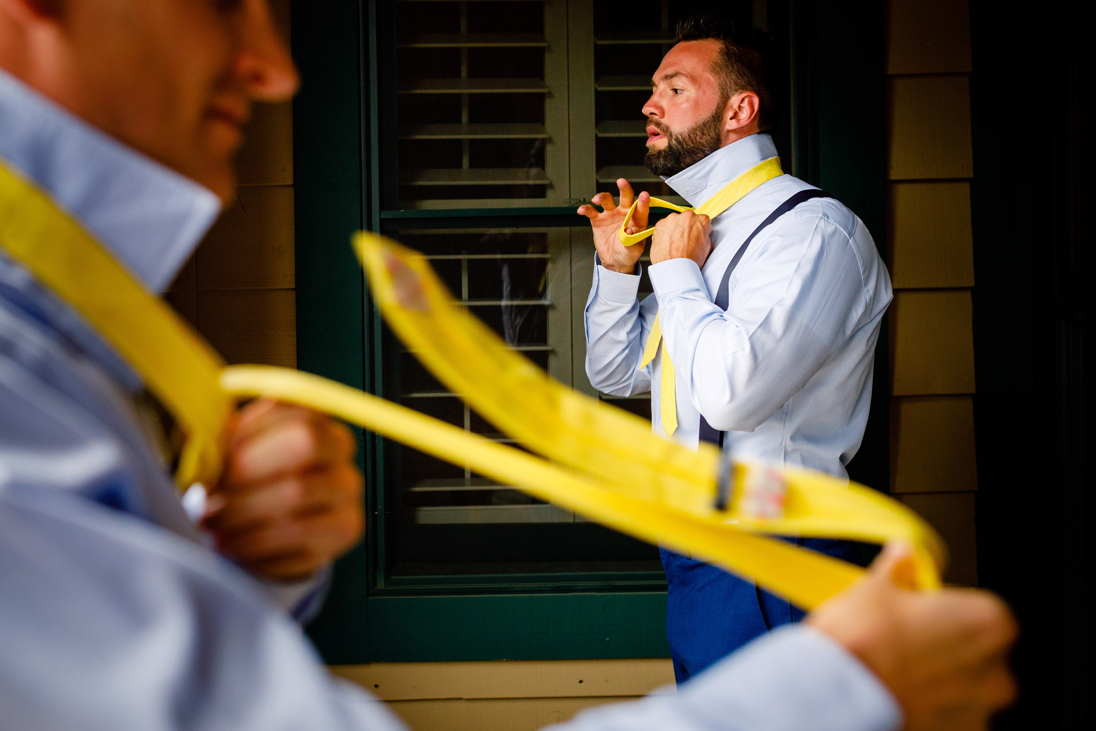 Groom putting on tie at Keystone for Mountain Wedding