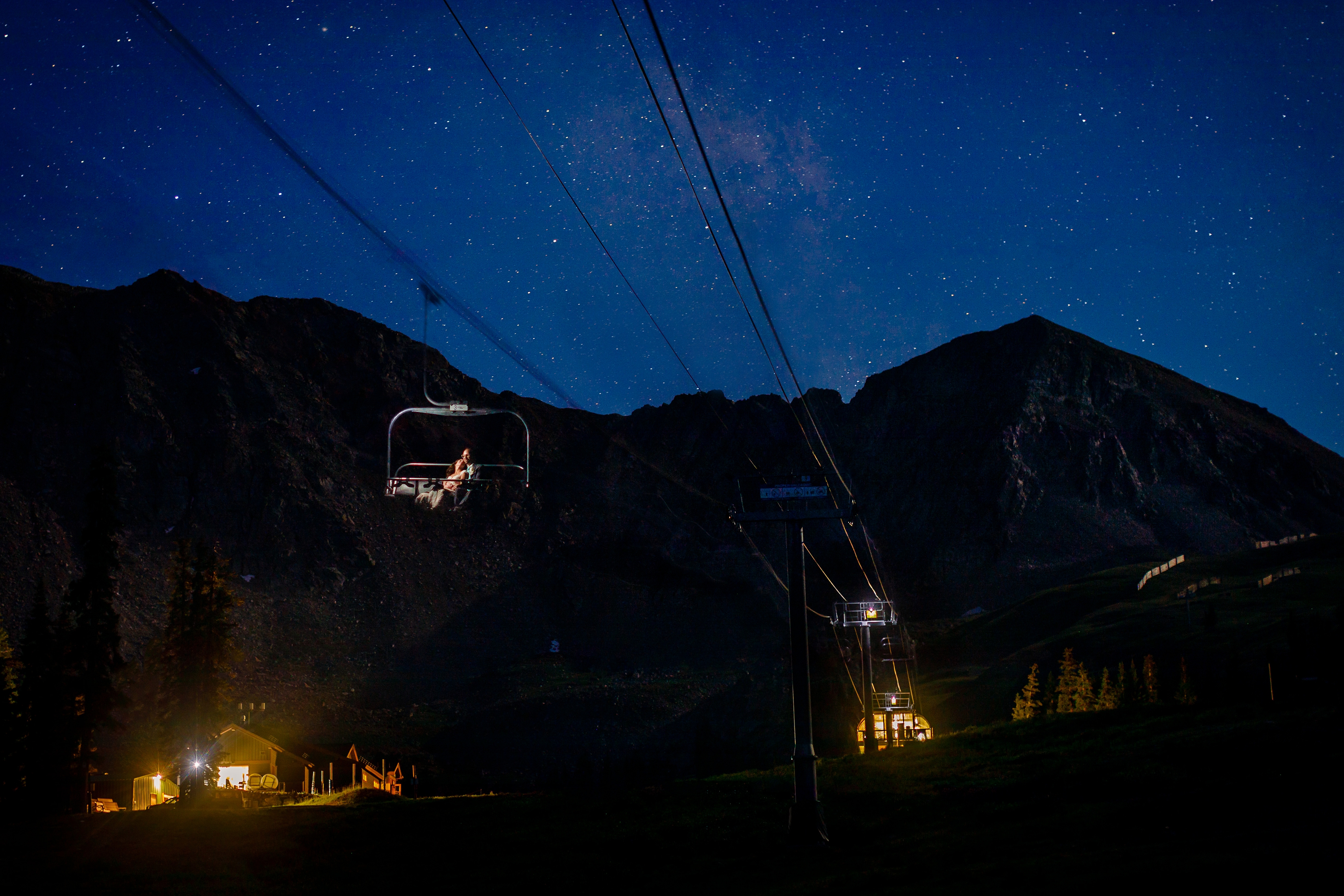 Epic starlit portrait of bride & groom riding the chairlift at Arapahoe Basin.