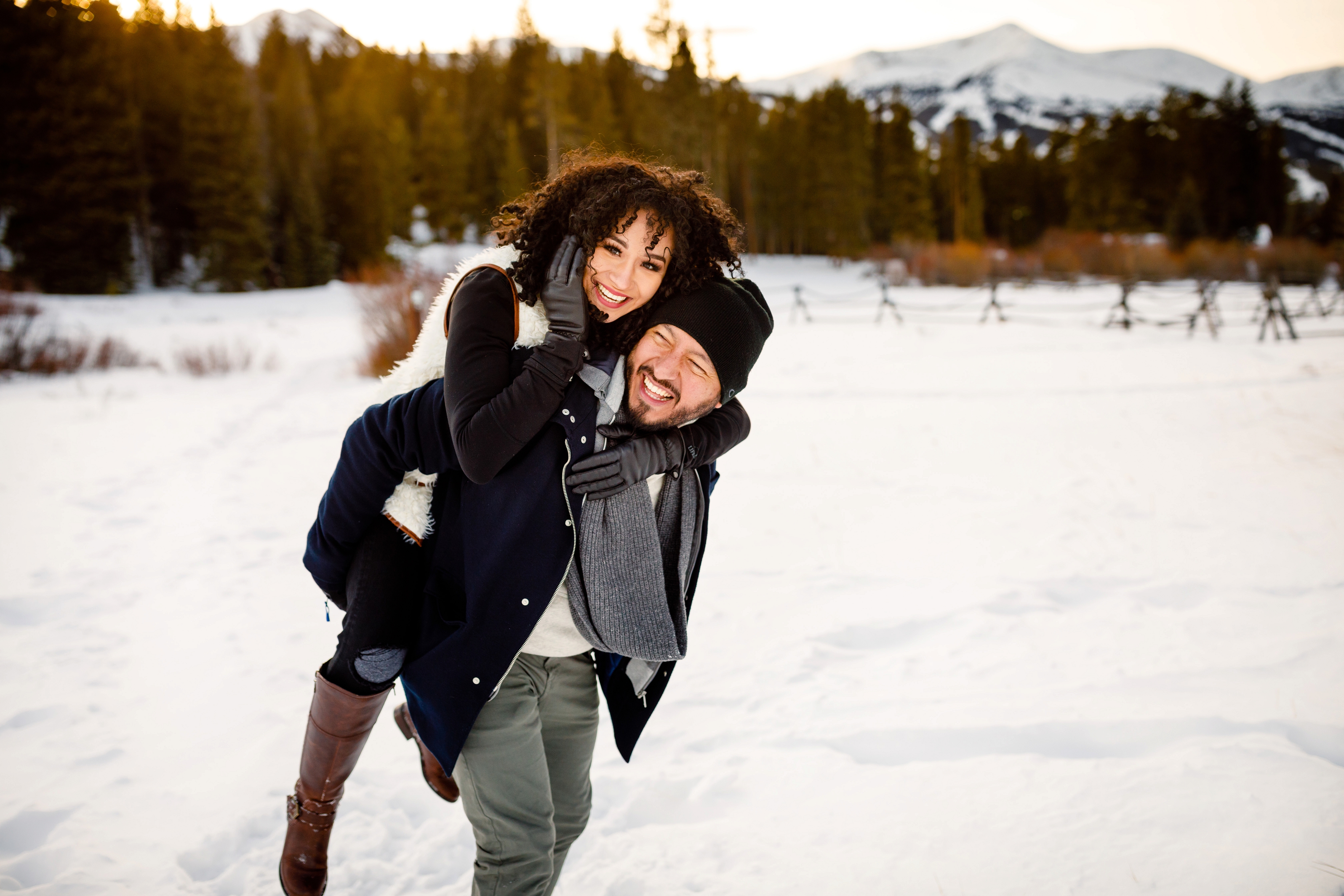 Robert gives Elizabeth a piggyback during their Boreas Pass Winter Engagement in Breckenridge.