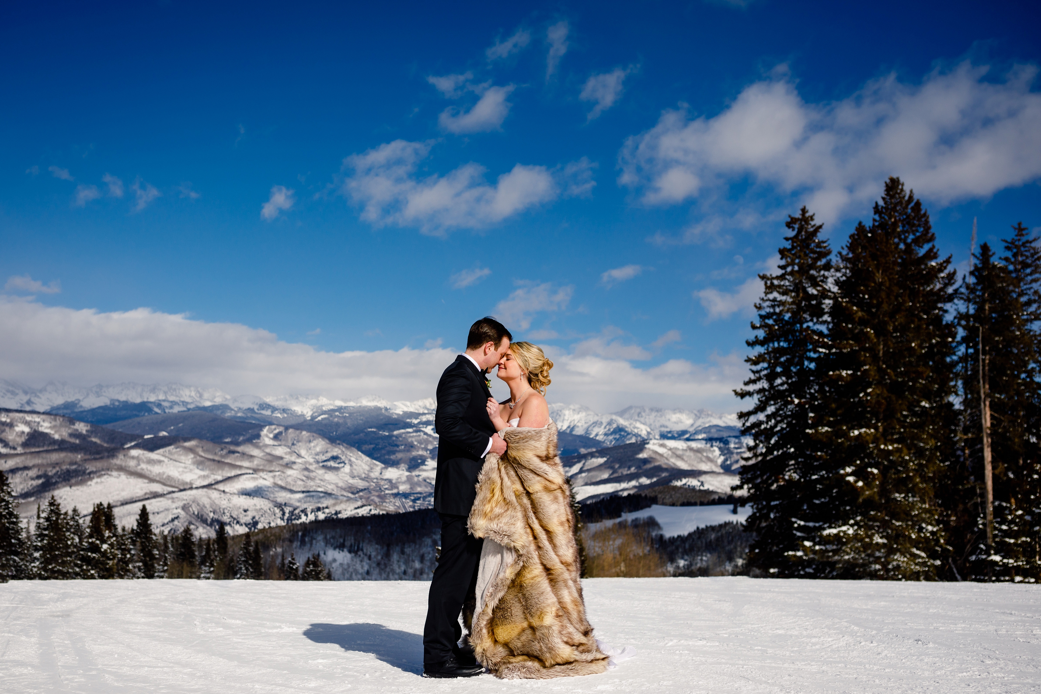 A beautiful wedding couple pose for a portrait on top of Beaver Creek Resort before their ceremony.