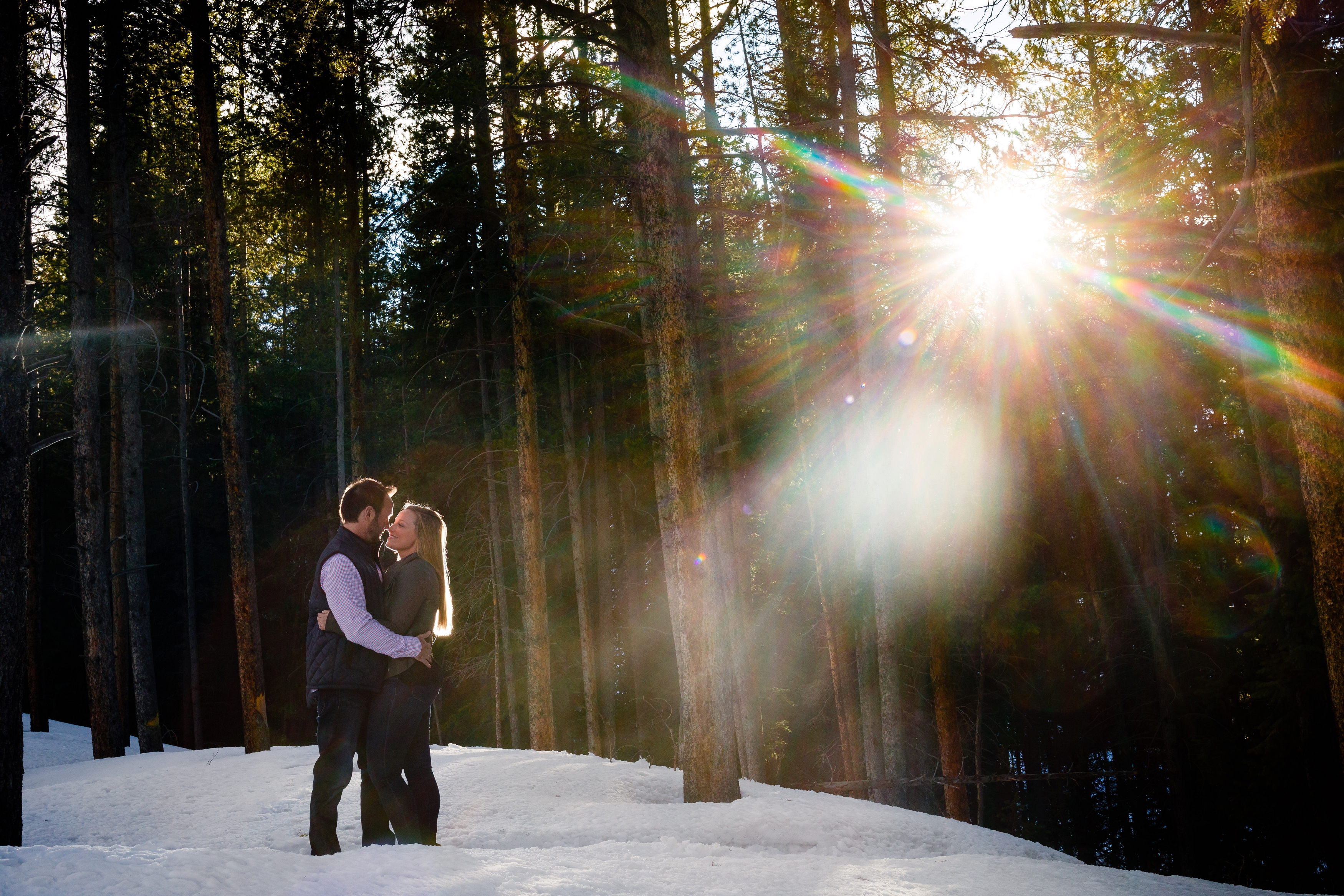 Warm rays of sun poke through the evergreen pine during these two's engagement session in Breckenridge, CO.