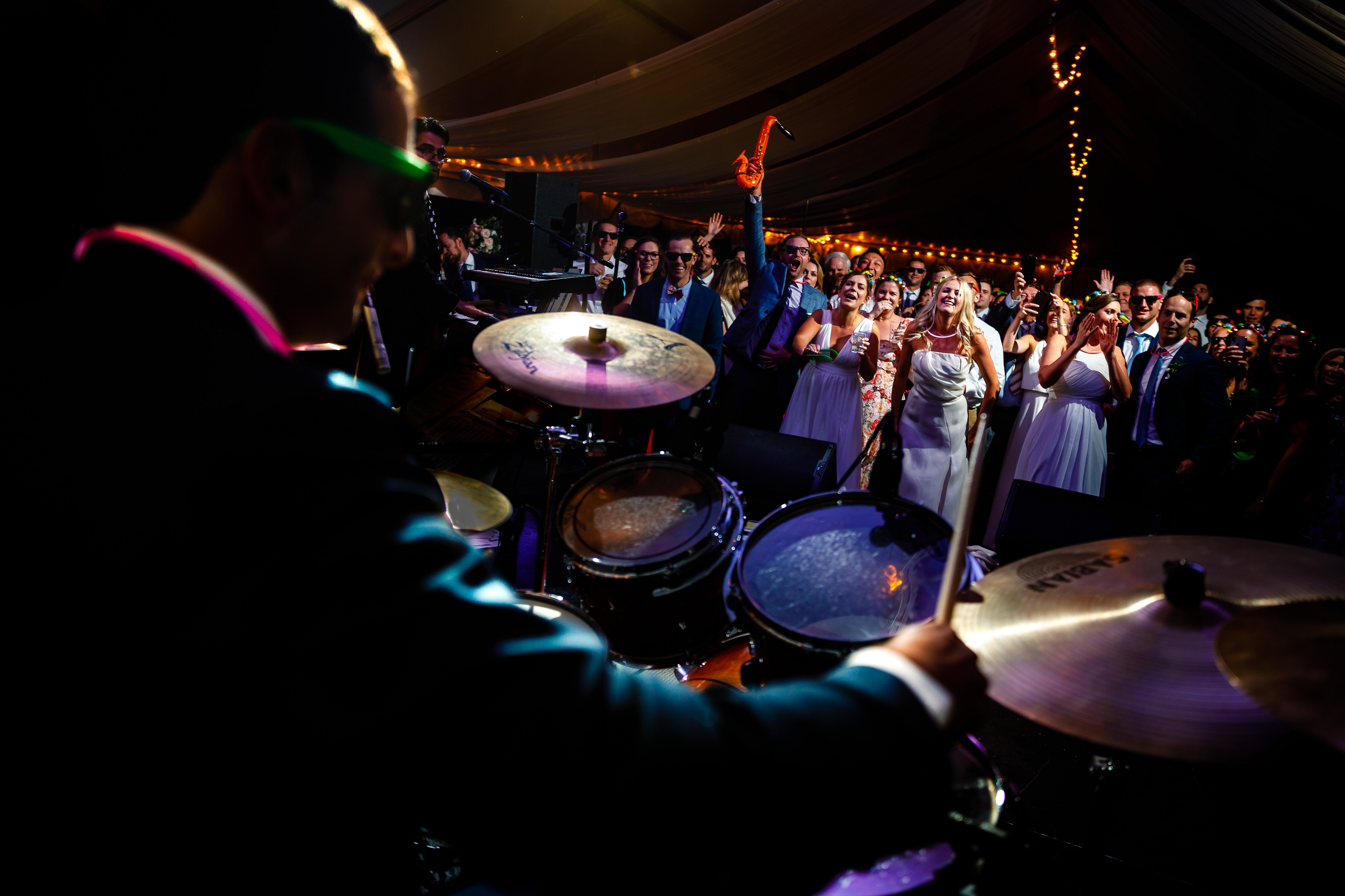 Groom playing the drums during the wedding reception at Camp Hale in Red Cliff, CO.