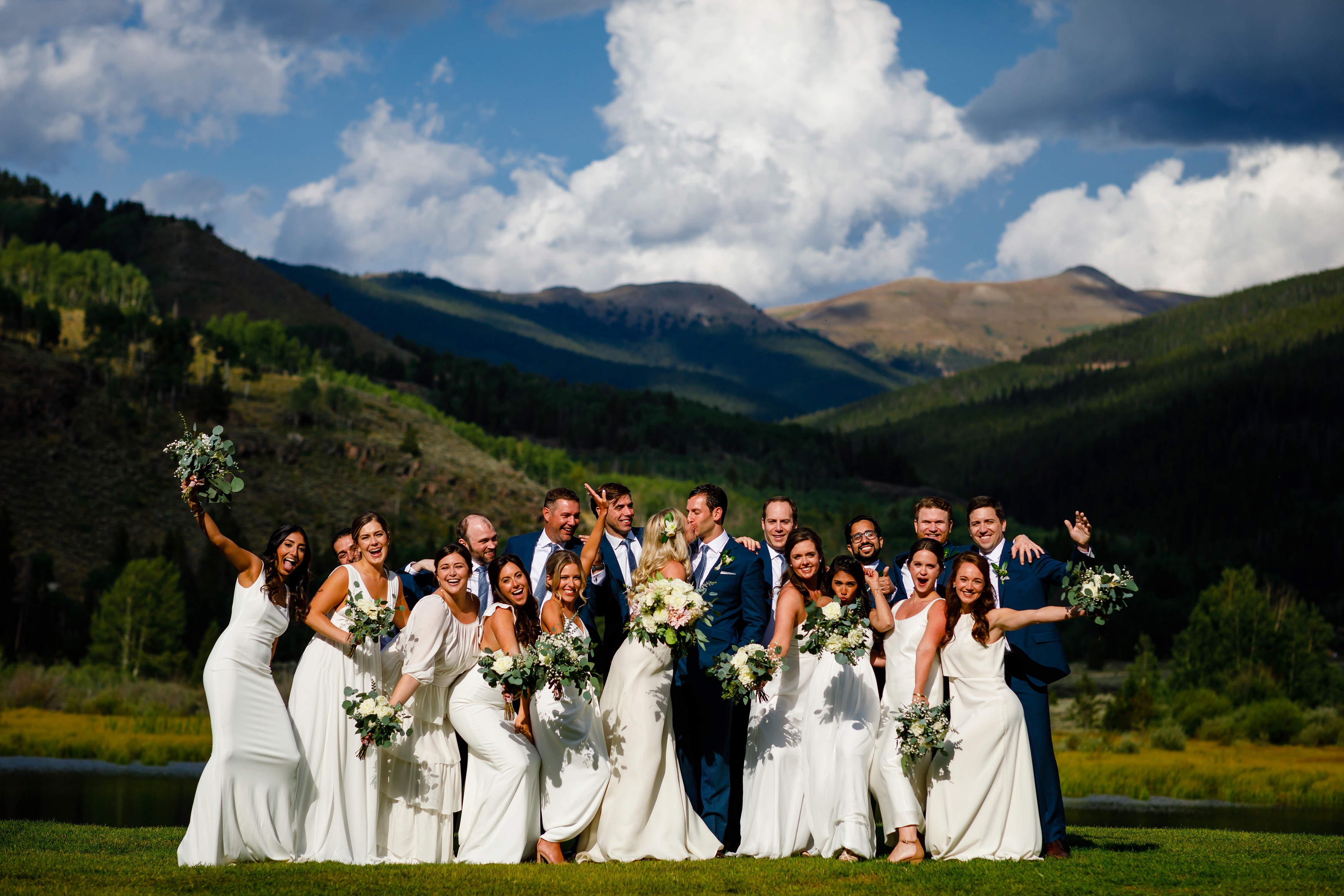 The entire wedding party celebrating Josh & Fabiana's marriage shortly after their ceremony on the ponds at Camp Hale.