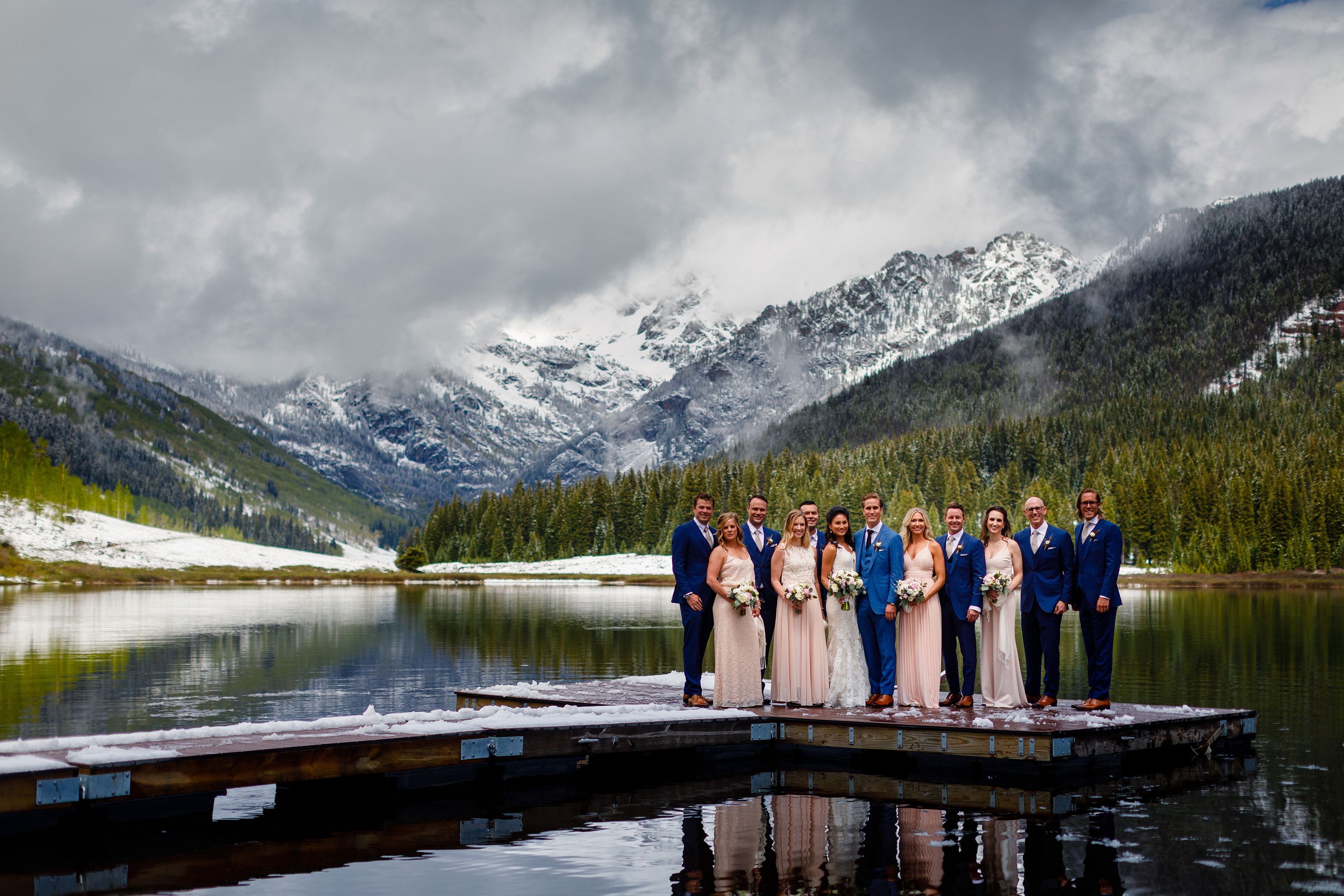 Whitney & Krystal's wedding party stand on the dock just after a snow had blanketed the Gore Range at Piney River Ranch.