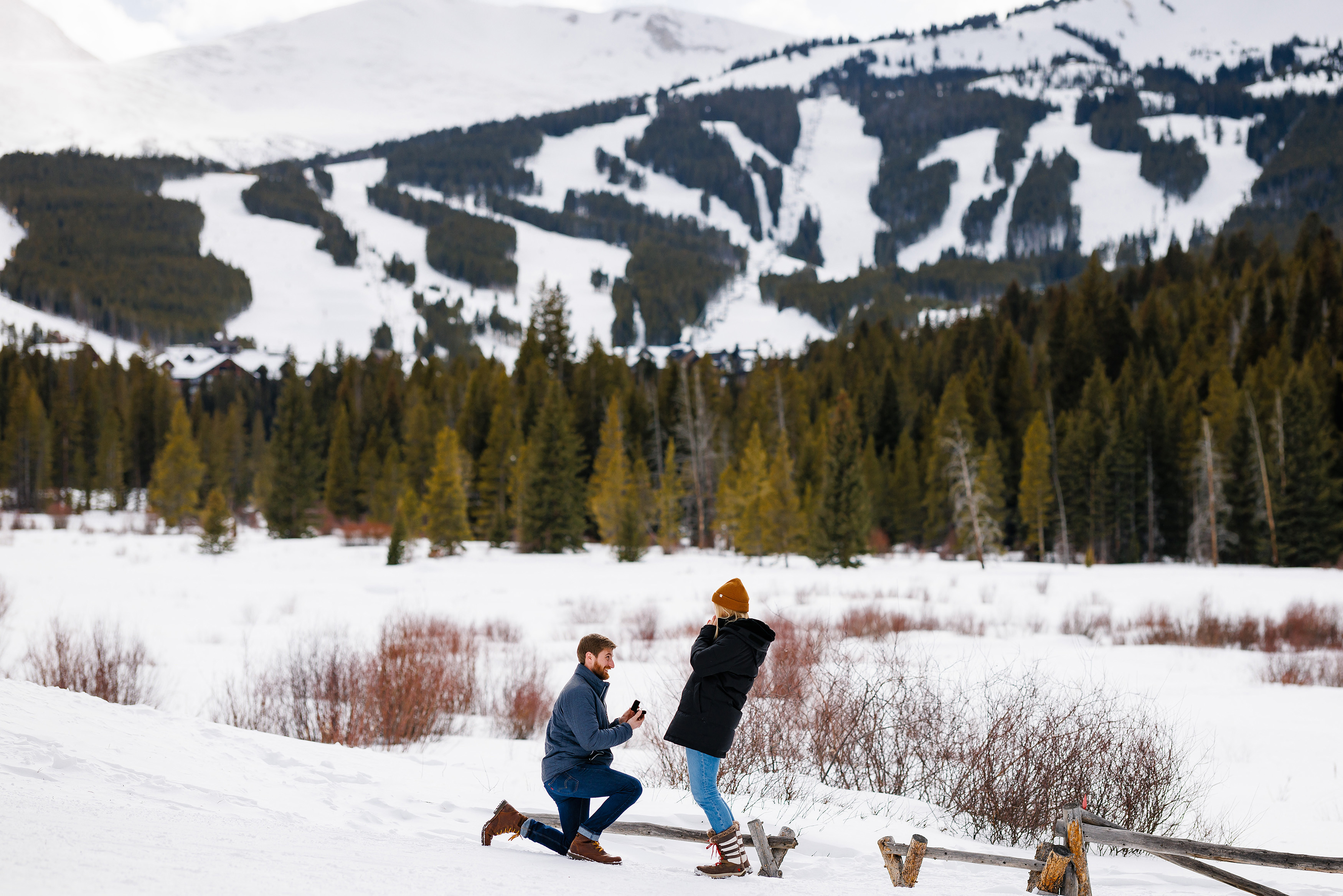 Zac on one knee as he proposes to Audrey at the Breckenridge Nordic Center.