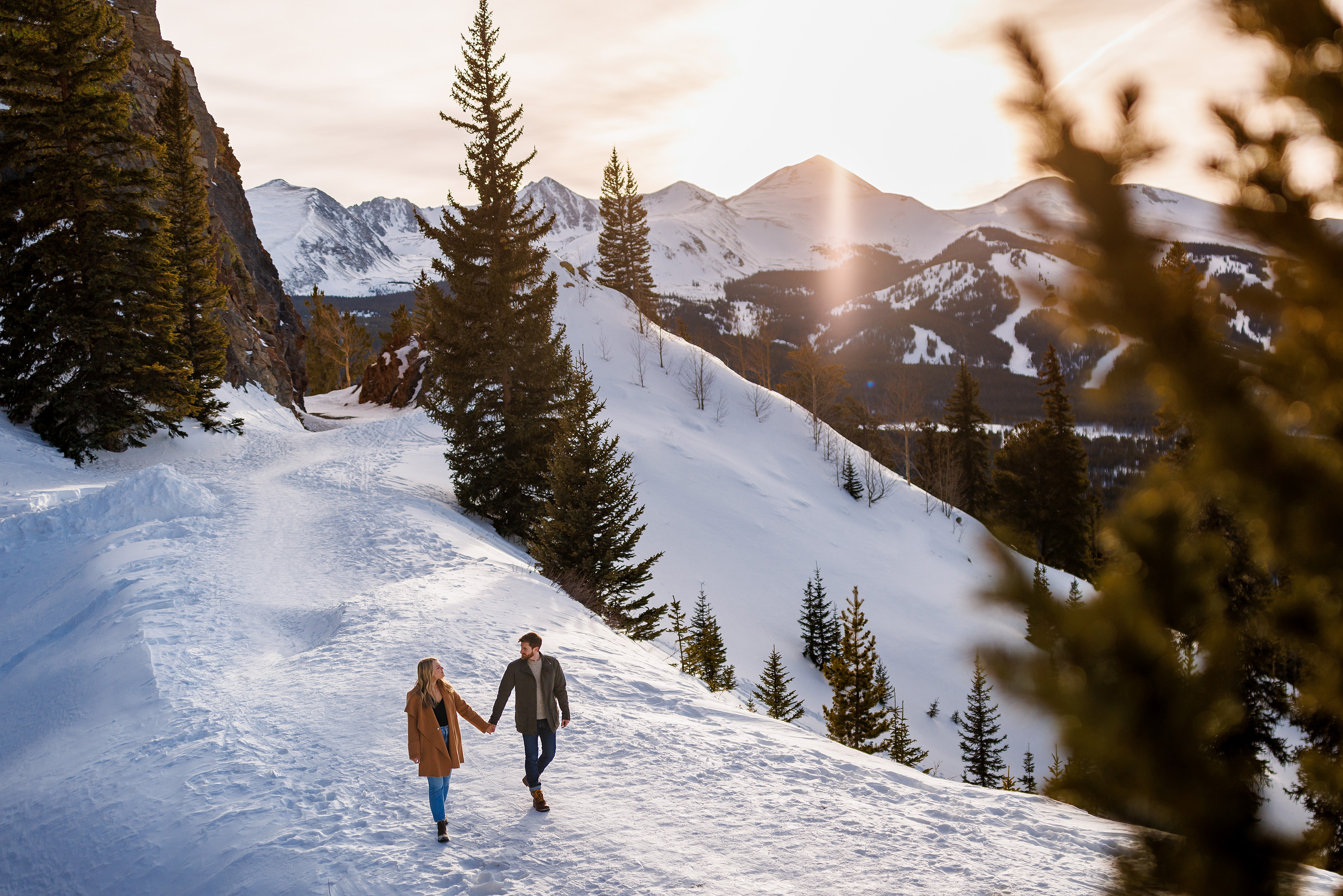 The couple walks along Boreas Pass near Breckenridge just before the sun sets over the Tenmile Range to the West.