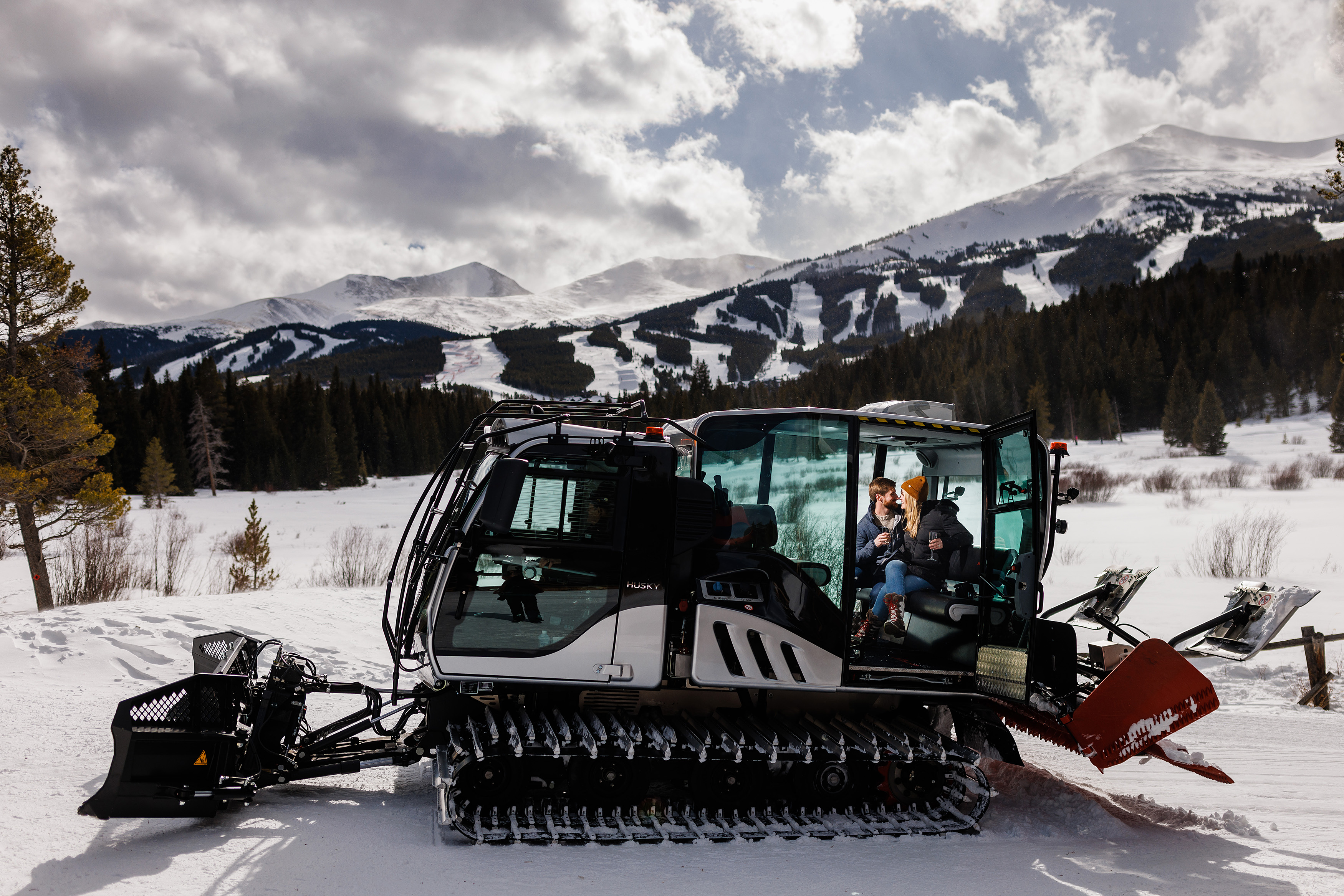 The newly engaged couple sit in a snowcat at the Breckenridge Nordic Center.