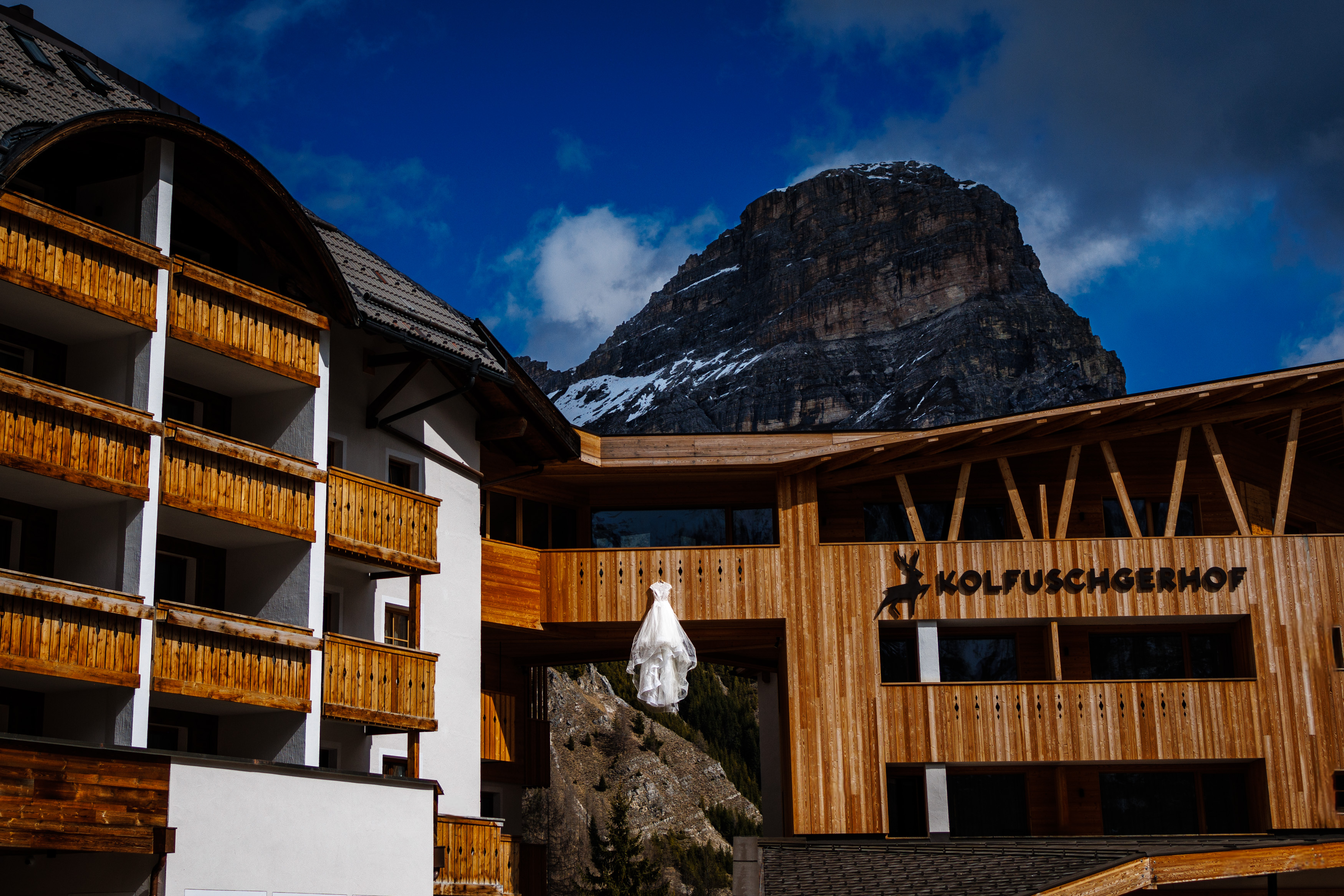 A Vera Wang wedding dress hanging from the balcony at Kolfuschgerhof Mountain Resort.